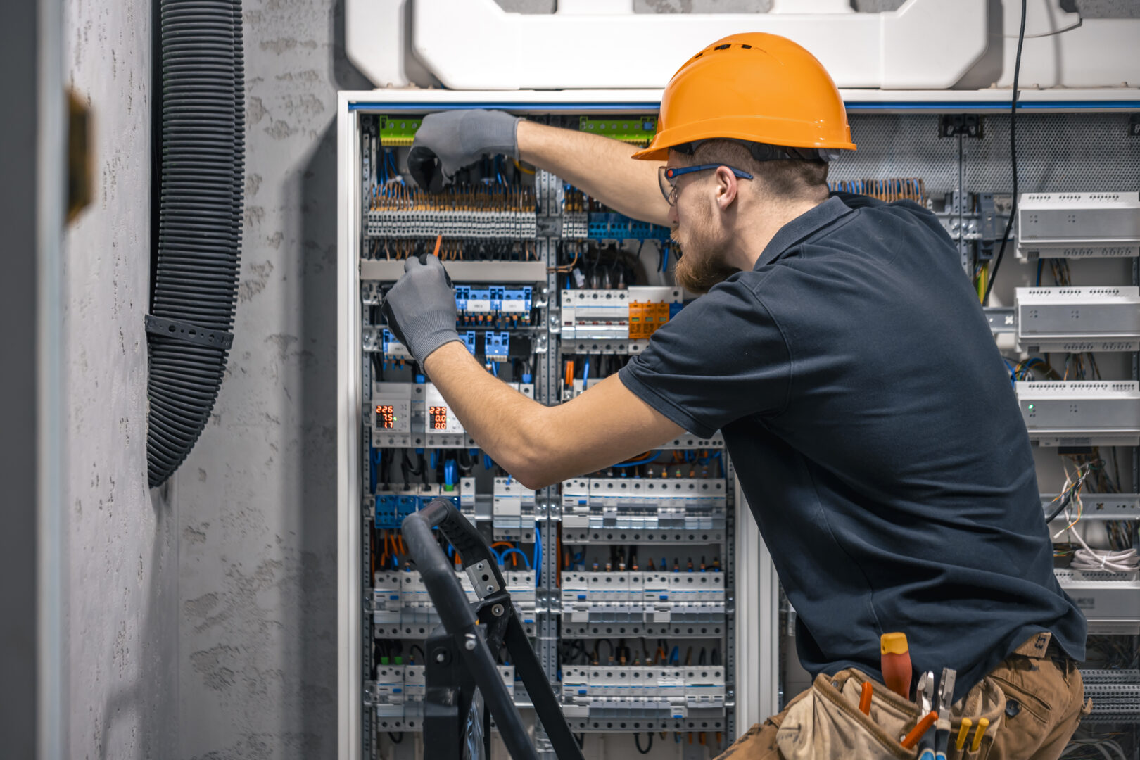 Electrical liability insurance male electrician working switchboard with fuses