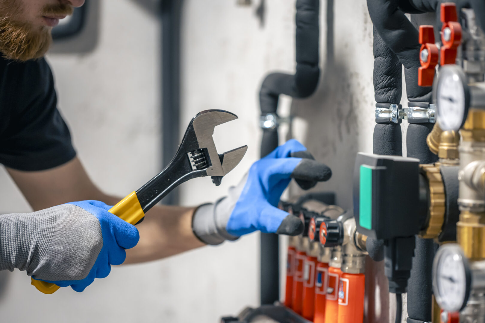 Plumbing Contractor Insurance man installs heating system house checks pipes with wrench